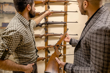 confident and affable salesman, consultant give good rifle, gun for hunting to look. customer want...