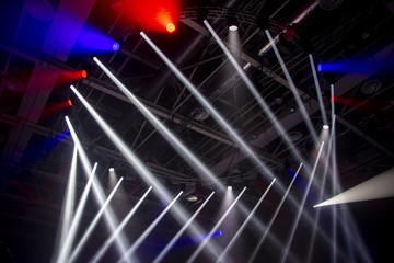 Spotlights. The stage for the performance is illuminated by floodlights. A ray of light breaks through the smoke.Lighting equipment for concerts and sports grounds.