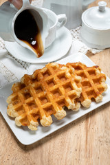 Tasty Belgian dessert, homemade Brussels sugar waffles with dark syrup