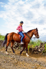 young rider on horseback ride in lush nature