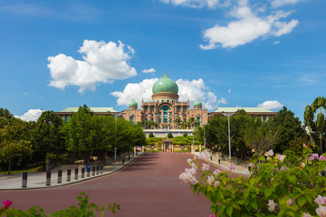 Prime minister office of islamic country Malaysia. Panoramic view from Putra Square. Malaysian government city Putrajaya. Wide angle cityscape. Flowers in foreground, the building on top of the hill