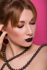 Obraz premium A beautiful young girl of European appearance with beautiful make-up on a pink background. Beauty Shooting