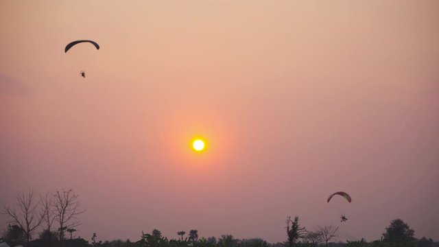 2 paramotor gliders gliding through the sun beautifully