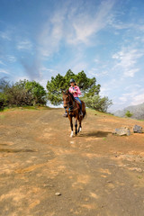 Obraz premium young woman walking and discovering the volcanic landscapes of Tenerife on horseback