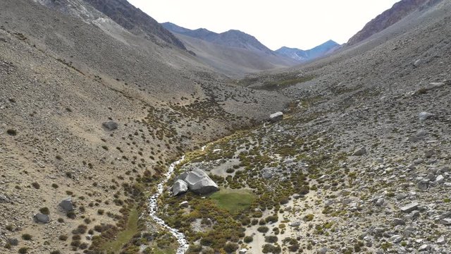 An aerial view inside Andes mountains at Limari Valley, south Atacama. An amazing wild scenery. Arid idyllic valleys with green farm fields feed in by the river at the bottom of the valley
