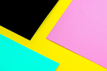 sheets of yellow, pink, and black paper on a blue background