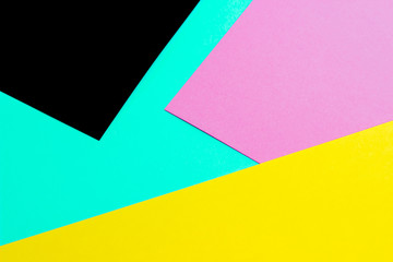 sheets of yellow, pink, and black paper on a blue background