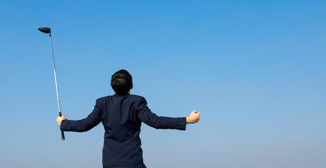 Back view of Young Asian CEO Businessman wearing suits playing golf at the golf course. Portrait of...