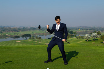 Young Asian CEO Businessman wearing suite playing golf at the golf course. Portrait of Asian businessman joying to success