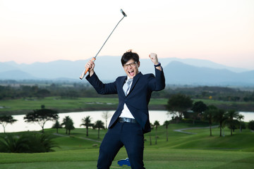 Young Asian CEO Businessman wearing suite playing golf at the golf course. Portrait of Asian businessman joying to success