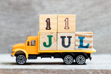 Truck hold letter block in word 11jul on wood background (Concept for date 11 month July)