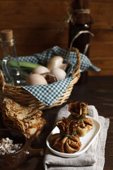  Pancakes with mushroom filling, a stack of pancakes and a basket with eggs close-up on a wooden background