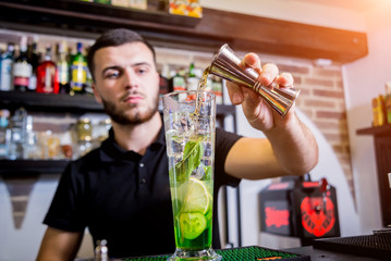 Bartender is making non alcoholic cocktail at bar counter. 