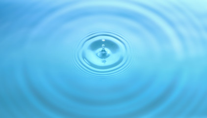 Water drop and circle ripple, light blue water, close up