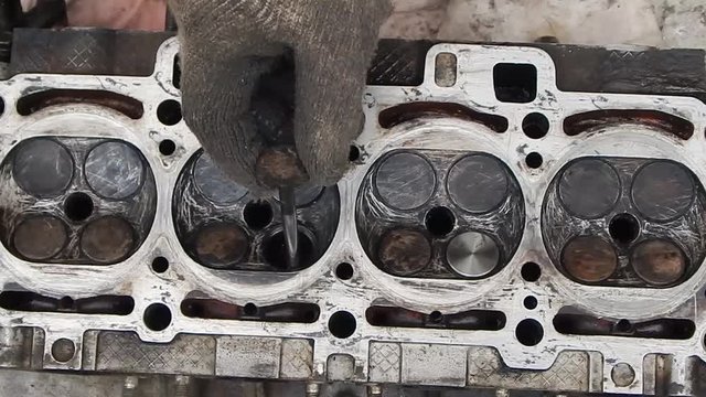Burnt exhaust valve. Valve block of the engine of the car.