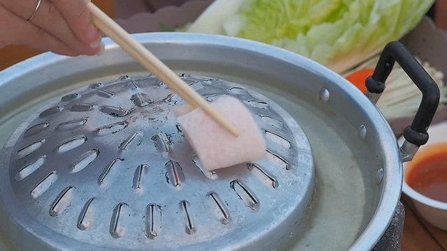 Closeup Place the pork fat cubes in a large pan or wok without any oil.   - Moo Katha in Thailand.