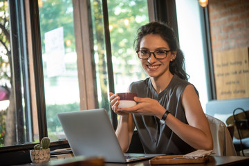 Beautiful woman have coffee in cafe while work in morning freelance, nomad work style