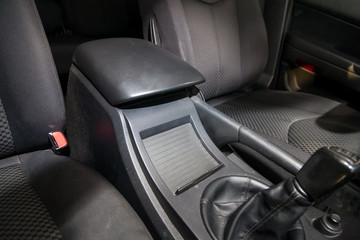 Interior view with cloth seats and car glove box of used car stands in the showroom after dry washing before sale. Auto service industry.