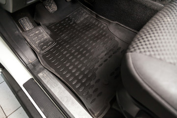 Сar floor mats of black rubber with gas pedals and brakes in the workshop for the detailing...