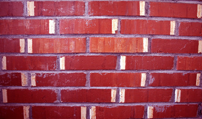 Obraz premium A red brick wall. Red with white stripes. Background. Rough stone.