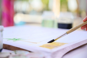 Close up hand of artist with brush painting picture handcraft