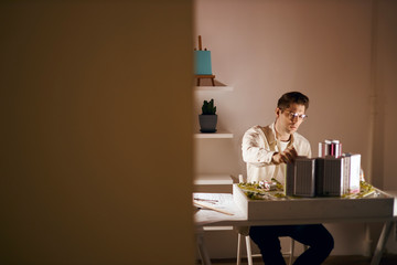 freelancer in glasses working in his room in the evening, at night, close up photo. copy space. designer creates interesting ideas