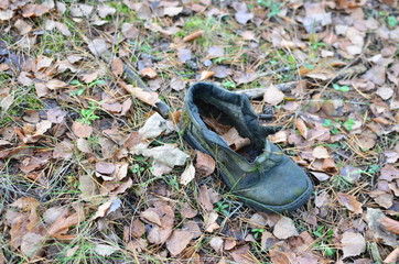 Man's shoes on a ground in the forest. Territory designation as a sign that there was a person here. Concept of the direction of the route, incident, loss, disappearance of a person