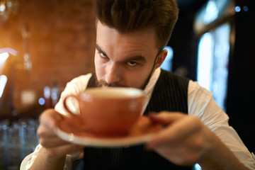 angry funny waiter giving a cup of coffee to client, serious barista holding a cup of drink, have your ever tasted this coffee, barista persuading clients to buy a cup of latte