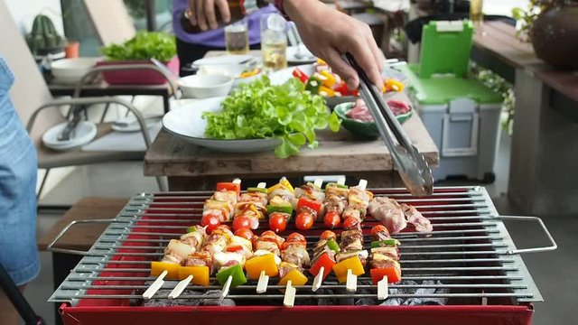 Men grilling pork and barbecue in dinner party. Food, people and family time concept.