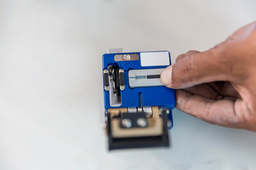 Optical fiber installation with Digital Fiber Optical Fusion Spl. High precision fiber optic cleaver is being used during a fiber optic wire installation at a house.  Welding of optical fibers. 