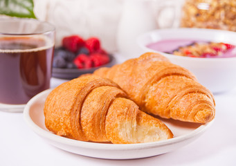 Fresh croissants buns, berries, black currant jam, smoothie bowl. Breakfast concept.