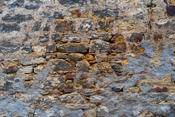 Antique brick wall collapsing from old age with crumbling bricks and a binder.