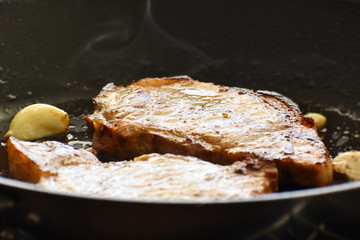 Pork chop on a frying pan. Selective focus. Concept for the ketogenic food. 