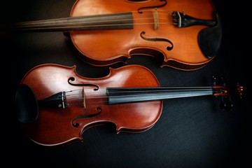 Violin put beside blurred viola,show different size and front side detail of acoustic instrument