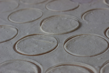 Dough rolled out in a pattern for preparation of ravioli or pelmeni. The rolled out dough. Rolled into a sausage dough. Flour dough for dumplings. Cooking dumplings