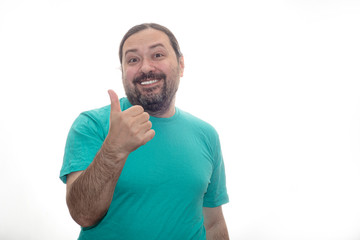 An untidily dressed and poorly shaved man joyfully shows a thumb up gesture. Isolated on a white background.