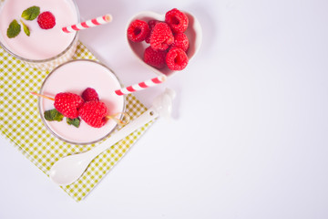 Two portions natural homemade yogurt in a glass jar with fresh raspberry. Breakfast concept. Copy space