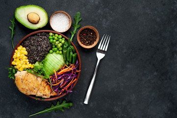 Bowl Buddha.Quinoa, chicken breast, avocado, red cabbage, arugula, carrot, green  peas, corn, broccoli, green beans in a plate on a stone background, with copy space for your text
