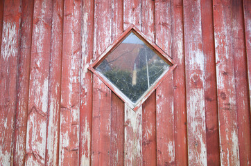 verwitterte rote Holzwand mit einem Fenster darin