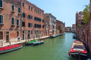 Obraz na płótnie Canvas View of narrow Canal with boats and gondolas in Venice, Italy