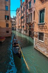 Obraz na płótnie Canvas View of narrow Canal with boats and gondolas in Venice, Italy
