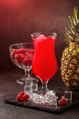 Delicious icy cocktail with fruits on dark grounge background. Healthy colorfull fruit shakes with ice on textured table.
