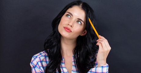 Obraz premium Young woman in a thoughtful pose on a black background