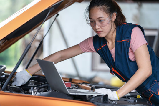 Girl engineer mechanics working on a vehicle in a garage or service workshop