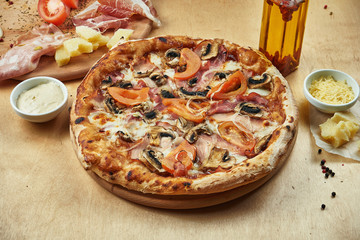 Close up view on Appetizing pizza with italian parma ham, mozzarella, mushrooms and tomatoes on...