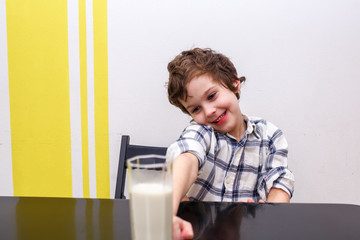 Fototapeta na wymiar Boy does not want to drink a glass of milk. Source of calcium. Concept of lactose deficiency