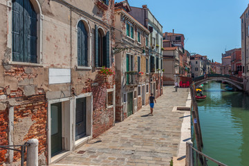 View of narrow Canal with boats and gondolas in Venice, Italy