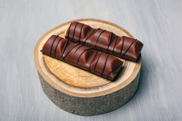 chocolate sticks on a forest wooden stand on a gray background sweets for joy close-up