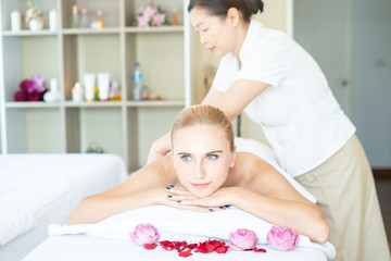 Obraz na płótnie Canvas Beautiful caucasian woman sleeping rest relax on bed for spa asia massage at luxury spa and relaxation. Thai masseuse massaged her back and shoulder in the spa room for office syndrome treatment