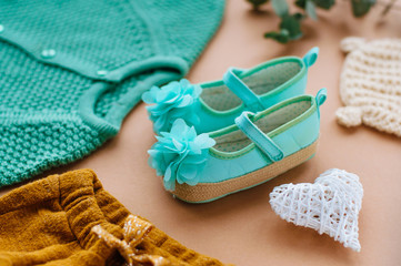 Close up of baby girl mint shoes on beige background